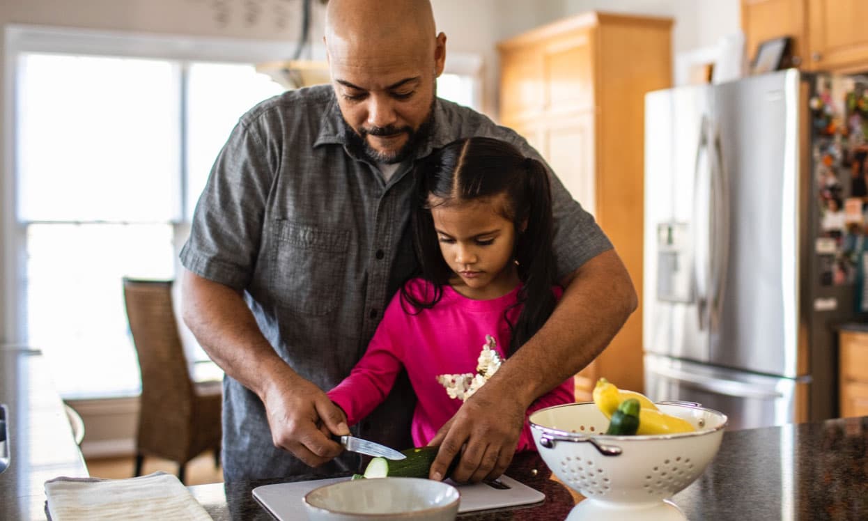 Father and daughter in the kitchen cooking depicting how important alpha-1 genetic testing is.
